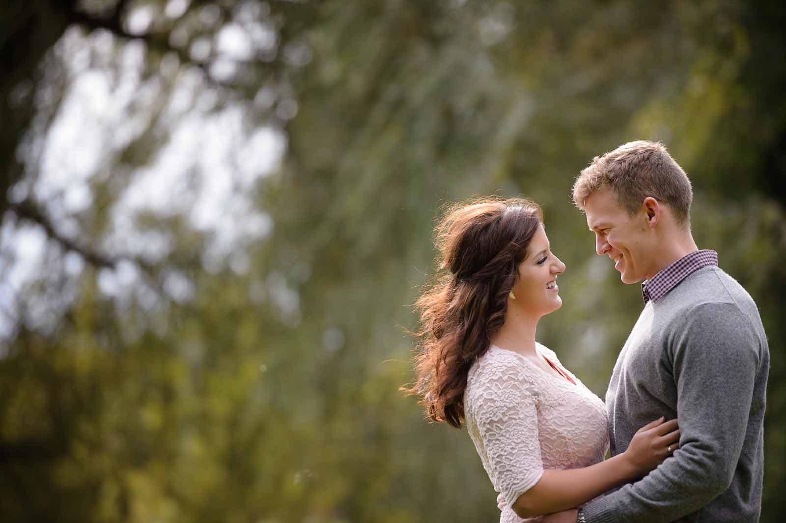 An couple looking lovingly at each other at their engagement session in the Glebe in Ottawa