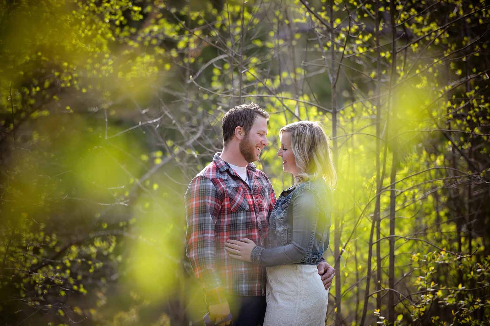 An engaged couple standing together in love in the warm sun in the country in Ottawa