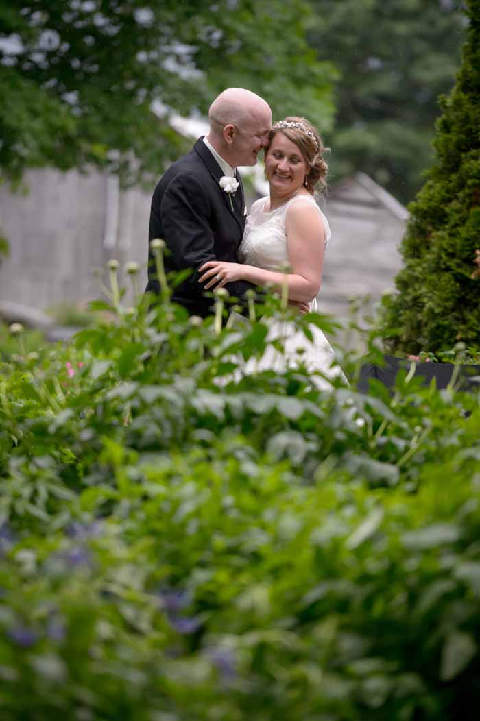 Couple embracing in the rain at their wedding at Stanleys Old Maple farm