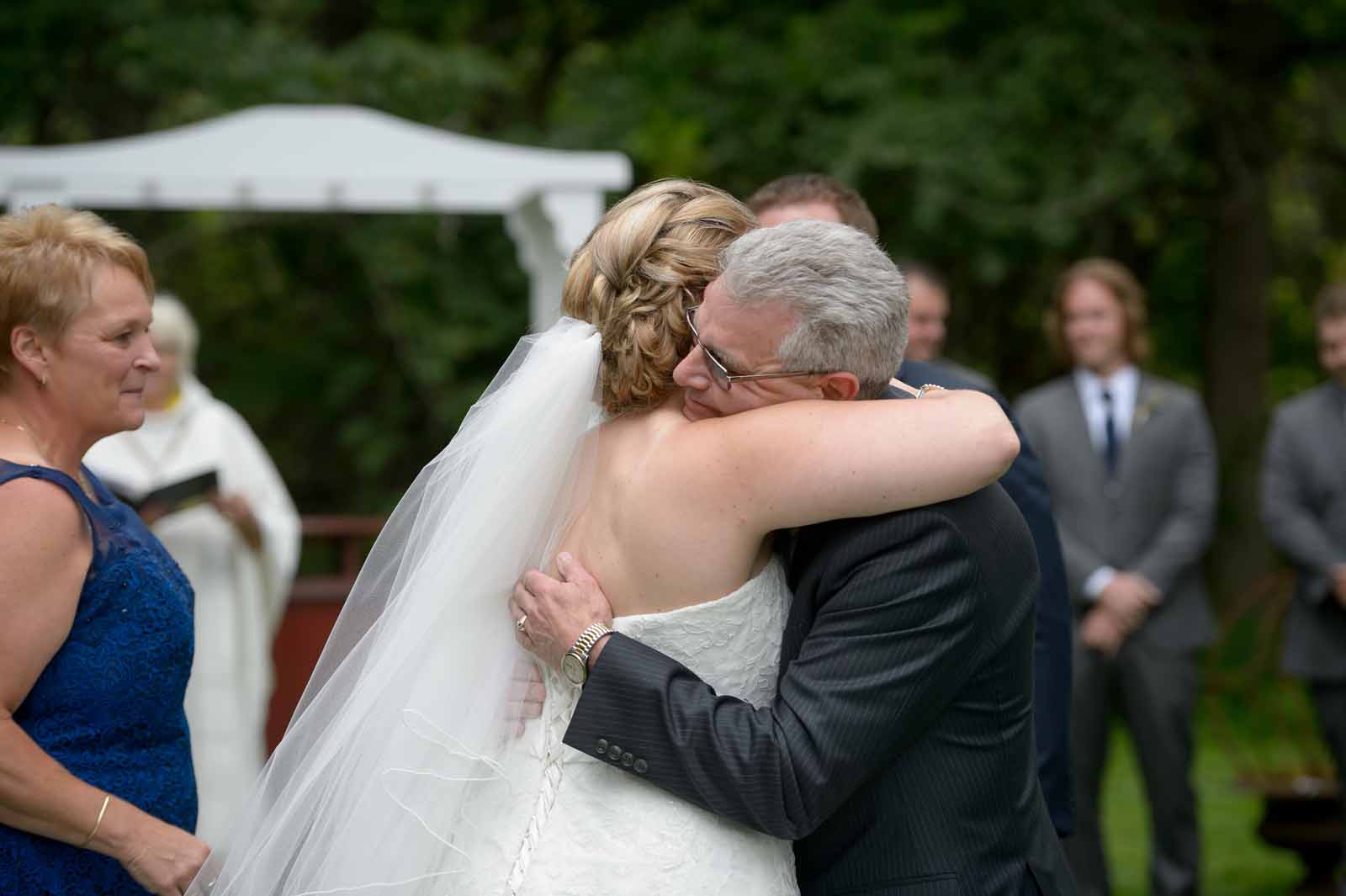 Newly married woman lovingly hugging her father with joy at her Ottawa wedding