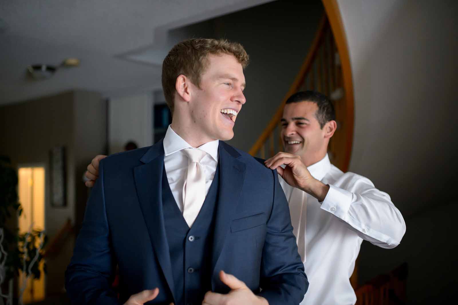 Ottawa groom getting his suit strightened by his best man while they joke about old memories