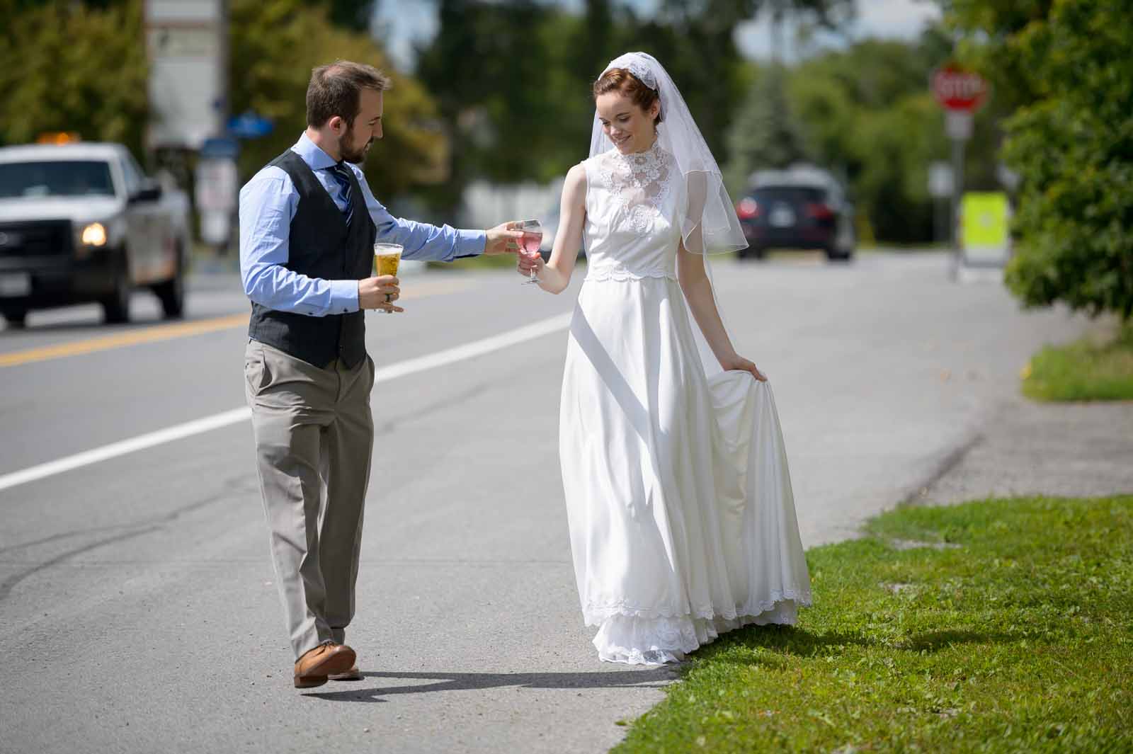 Bride and groom having beers and walking along on their wedding day