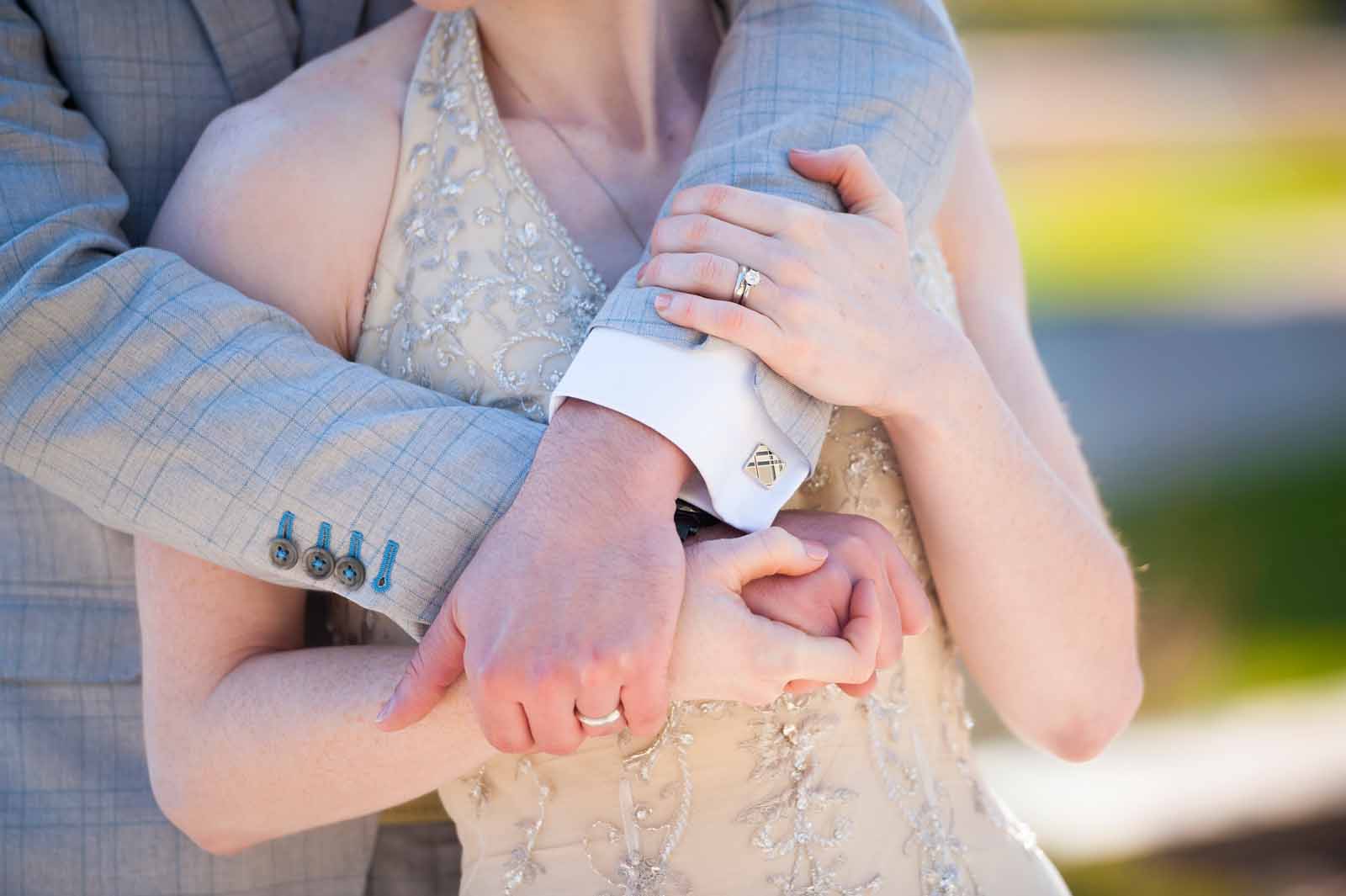 A closeup of a couples arms while embracing on their wedding day