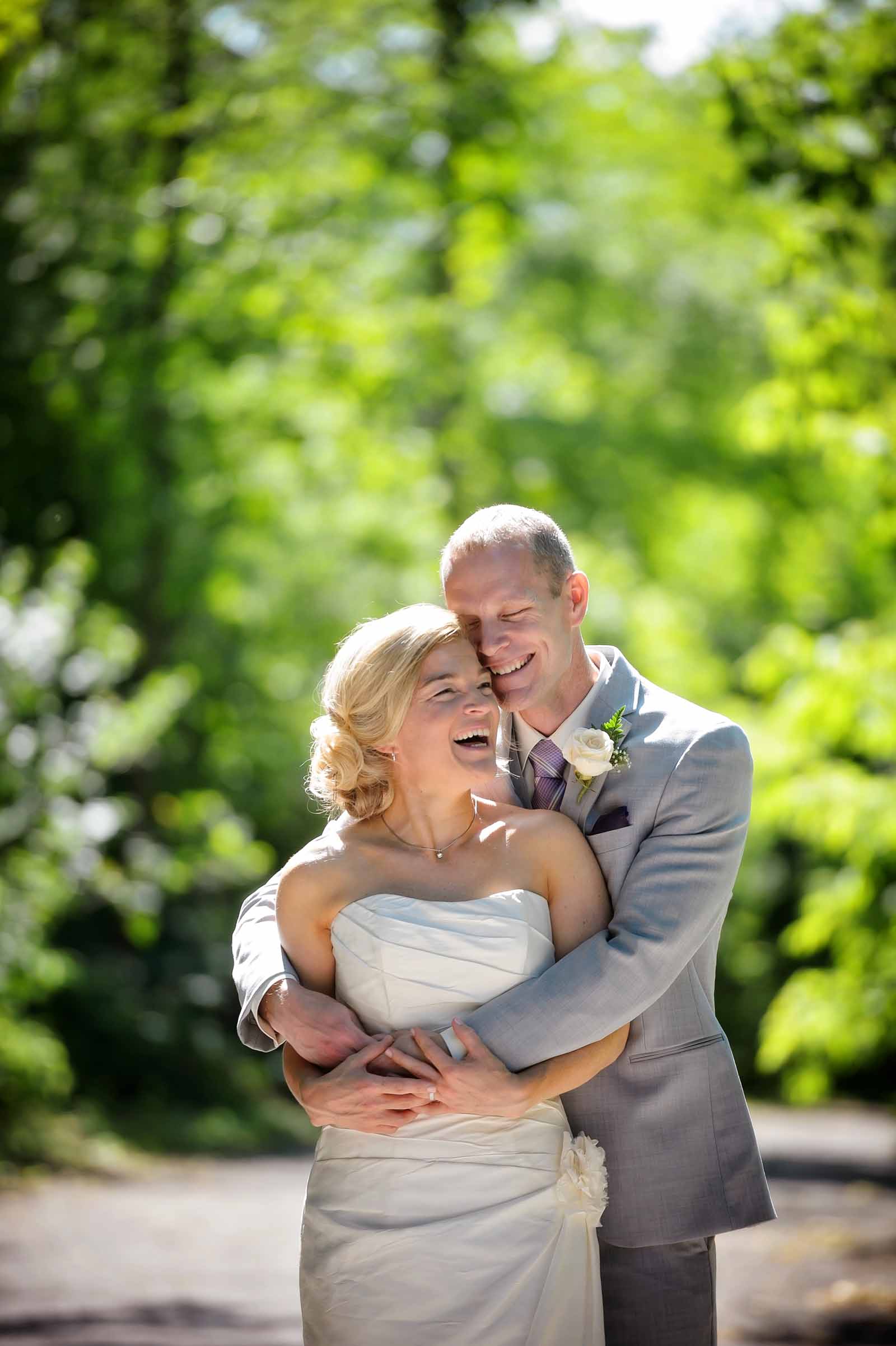 Couple embracing amongst yellows and green folliage on their wedding day