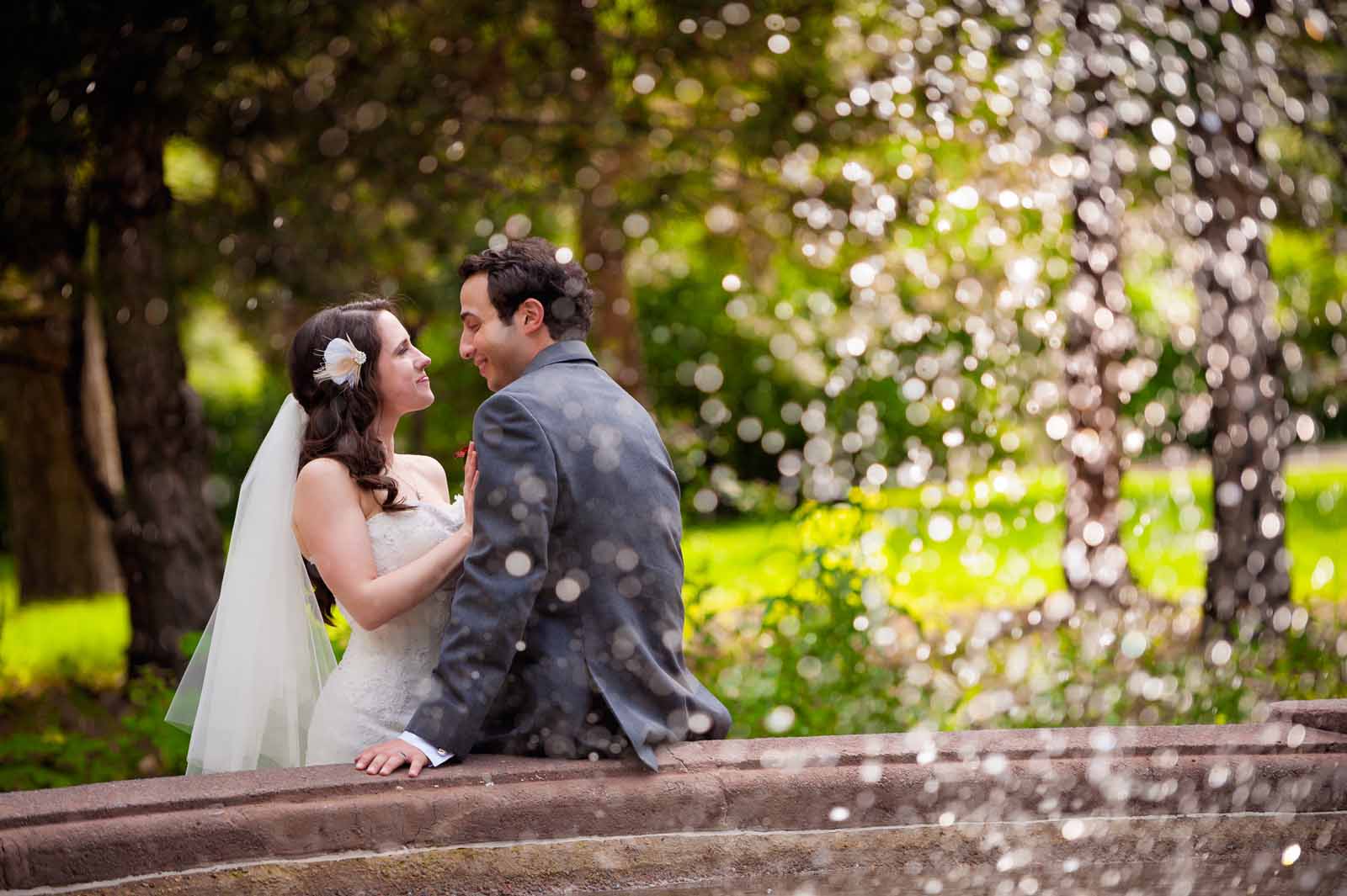 Couple looking lovingly into each others eyes with a waterfall dancing around them at Strathcona Park in Ottawa