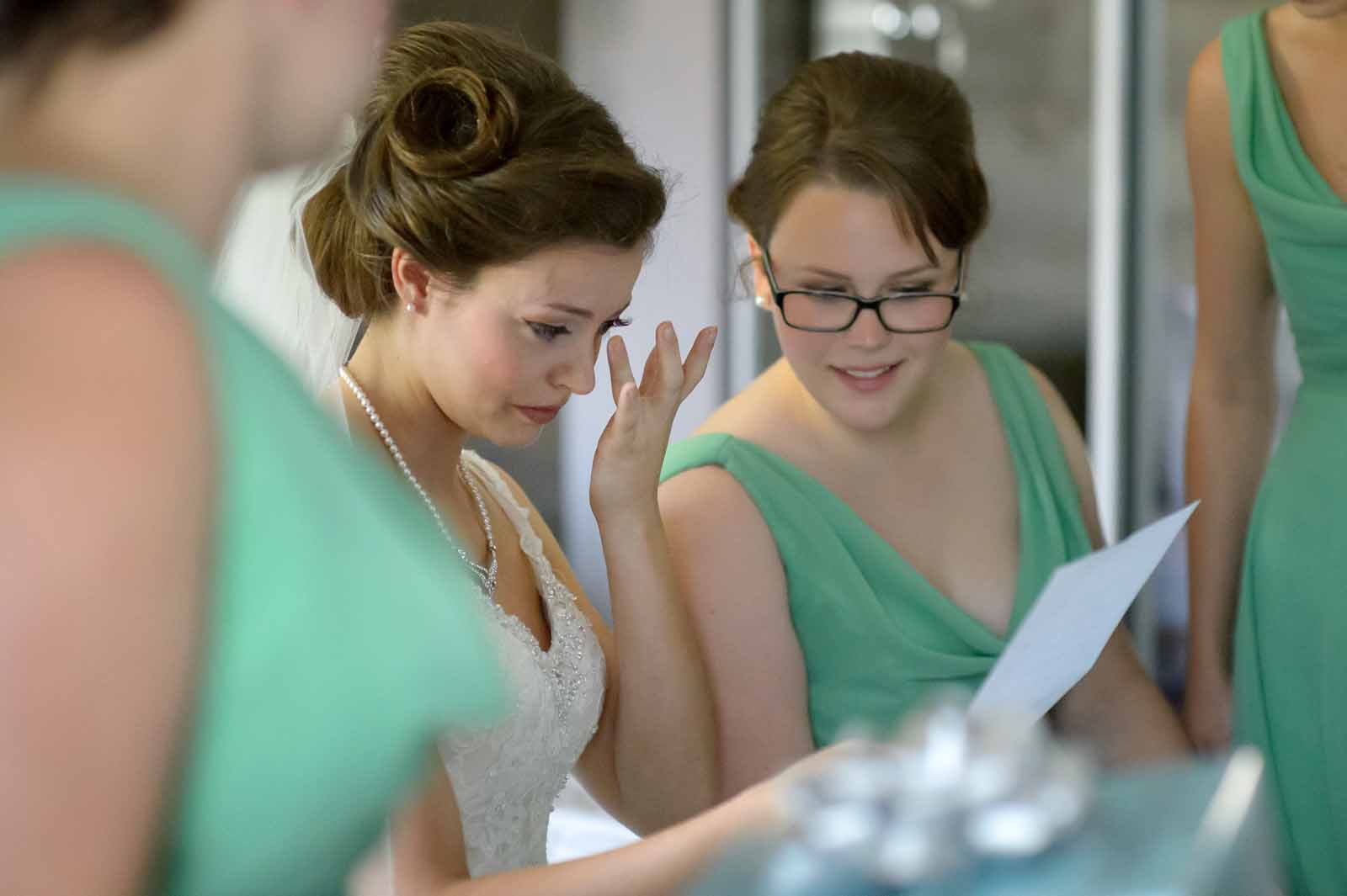 Bride crying happy tears while reading a note from her groom on their weding day