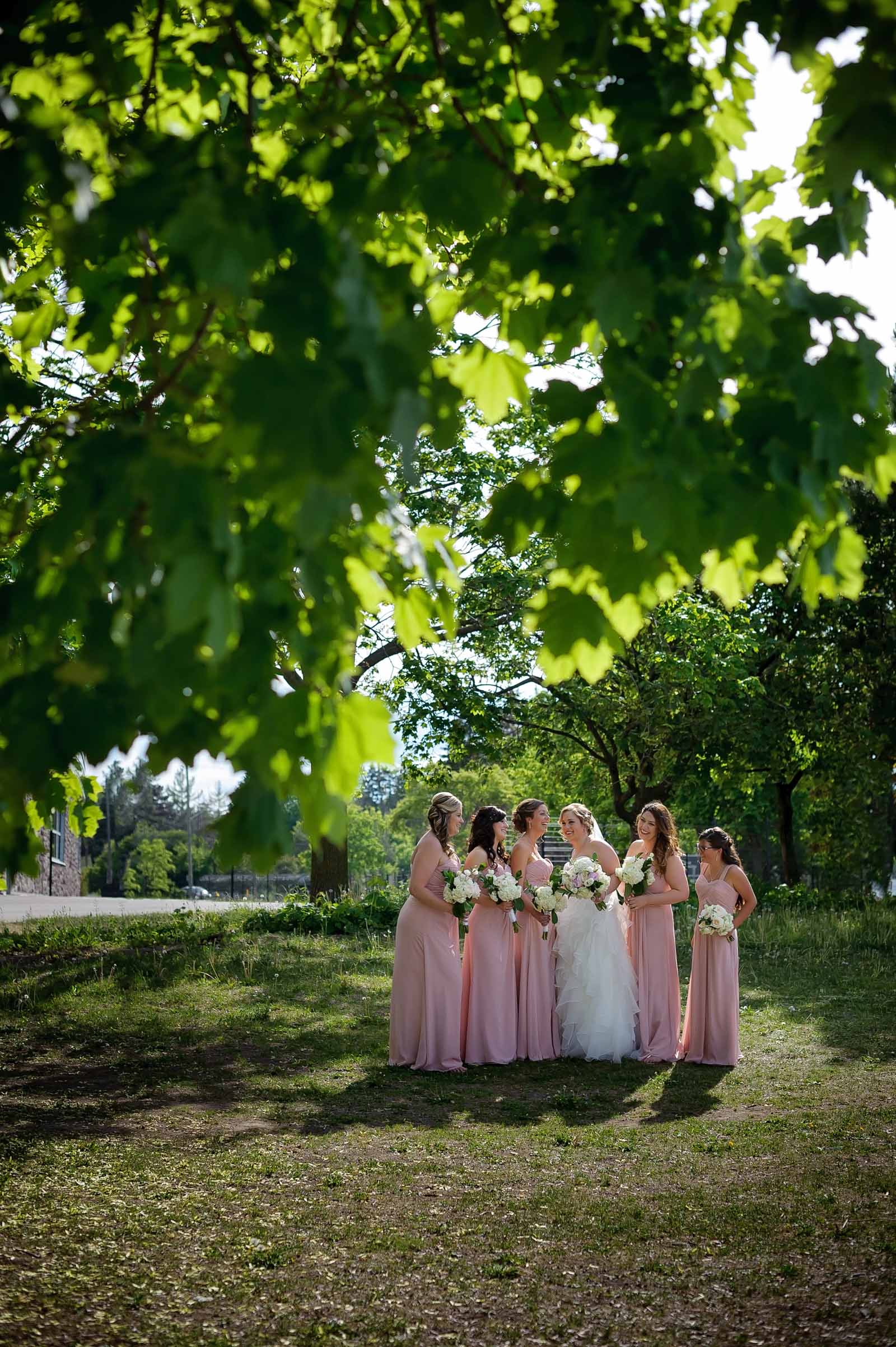 Bride and her bridesmaids laughing amongst the leaves at Lago at Dows Lake in Ottawa