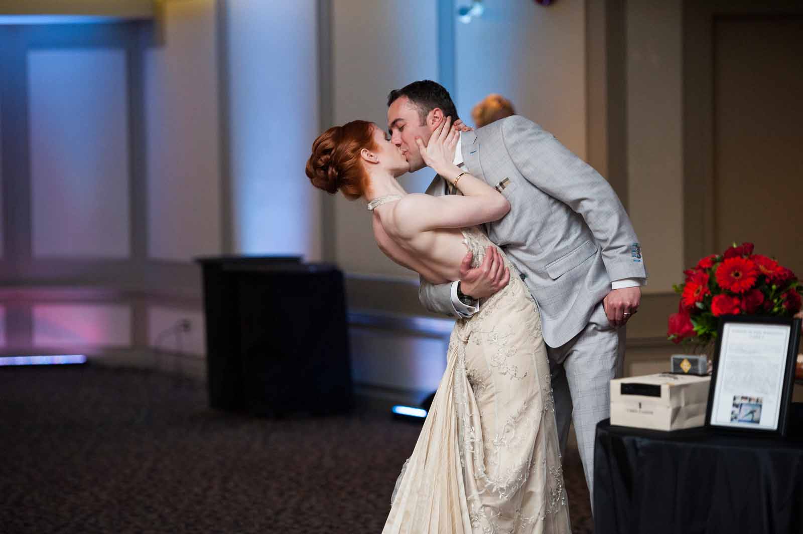 A dip and a kiss by the bride and groom at their wedding reception