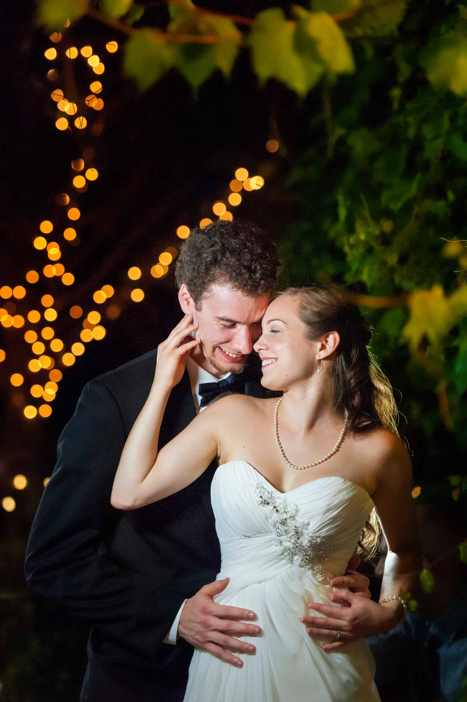 A couple embracing at night outside their wedding reception at Strathmere