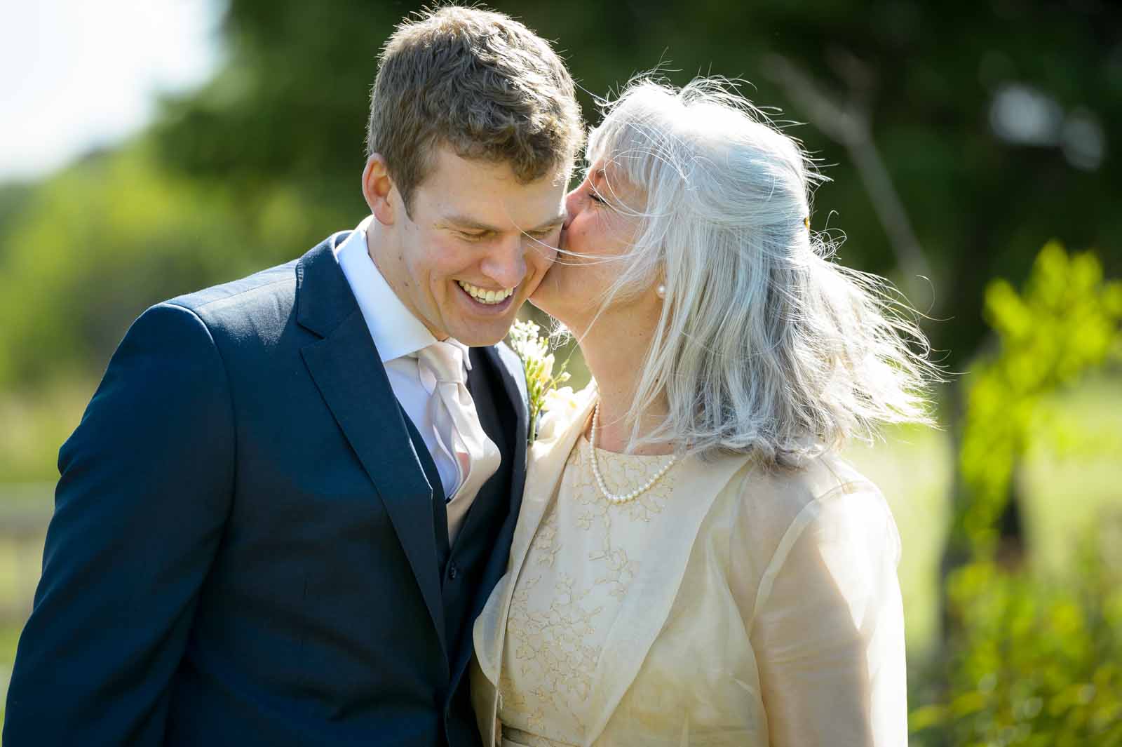 A groom receiving a kiss from his Mother on his wedding day at Orchardview